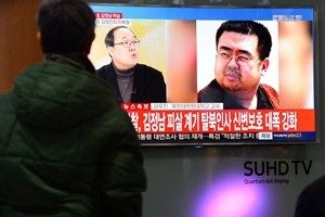 People watch a TV screen broadcasting a news report on the assassination of Kim Jong Nam, the older half brother of the North Korean leader Kim Jong Un, at a railway station in Seoul