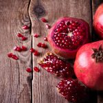 Some red pomegranates on old wooden table