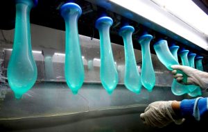 FILE PHOTO: A worker performs a test on condoms at Malaysia's Karex condom factory in Pontian