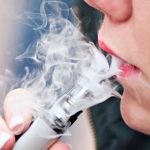 Closeup of mouth of woman with e-cigarette in outdoor