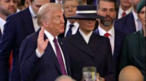 Donald Trump durante il giuramento con a fianco la moglie Melania